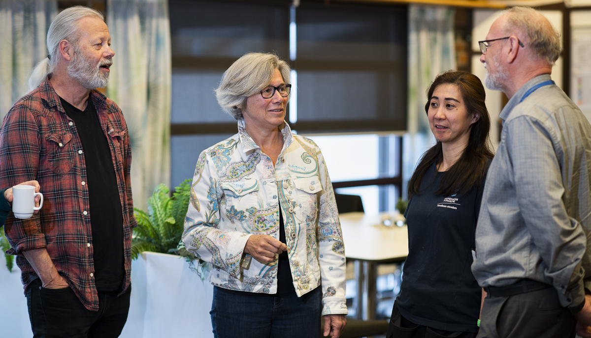 Rektor Gro Kristiansen i samtale med tre kolleger inne i skolebygget.