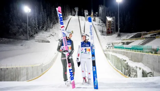 Foto av Johann André Forfang og Eirin Kvandal foran hoppbakkene i Granåsen