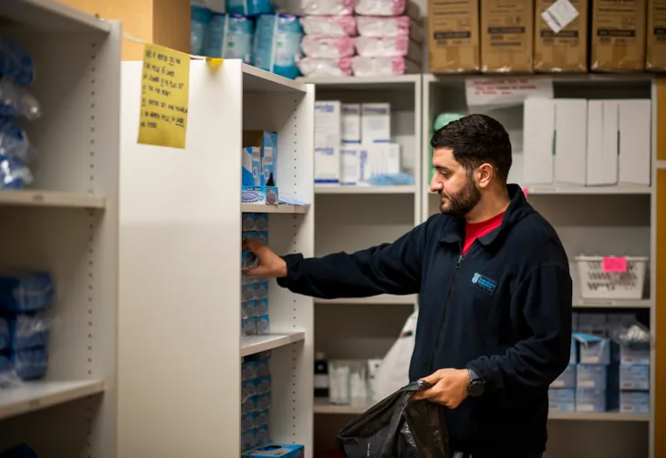 Malik henter utstyr på lageret som han skal ha med seg i en pose.