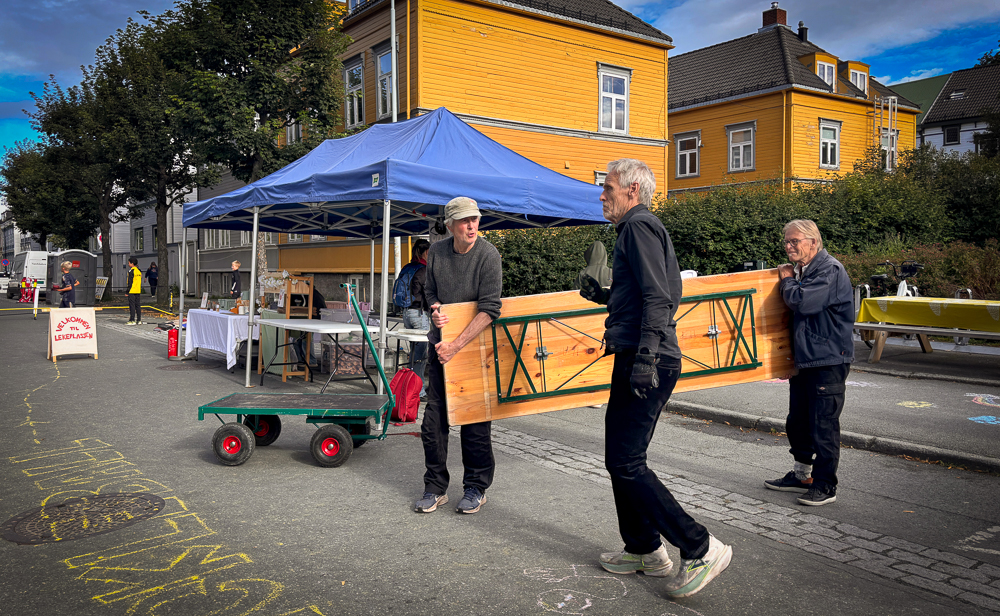 Tre menn bærer bord.