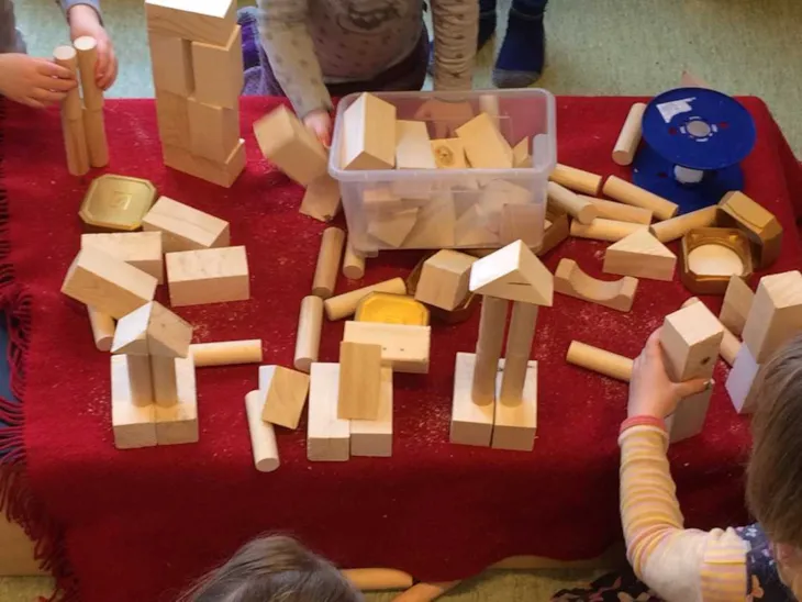 Bygger med treklosser på rødt underlag