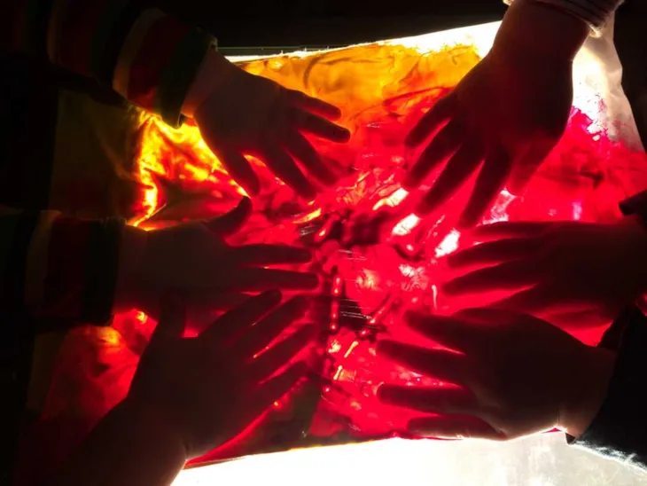 Småbarn maler på gjennomsiktig underlag på lysbord