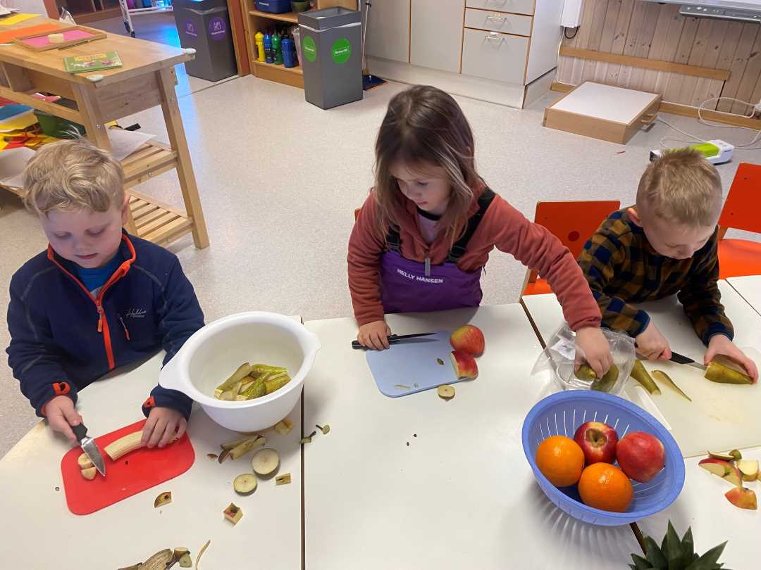 Barn kutter opp frukt f&oslash;r m&aring;ltid