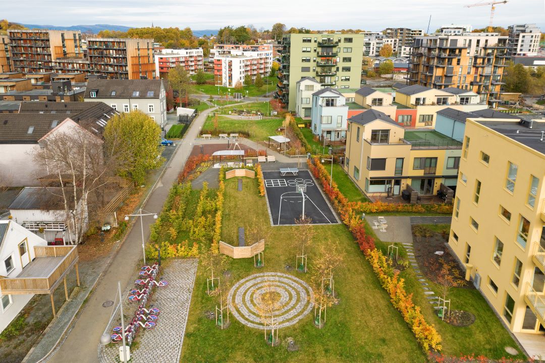 Oversiktsbilde av park med ballbinge som ligger mellom boligblokker