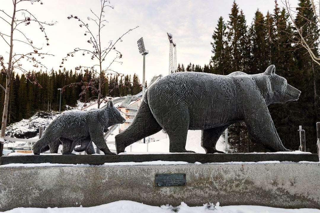 En statue av en bj&oslash;rnebinne og to unger som g&aring;r bak