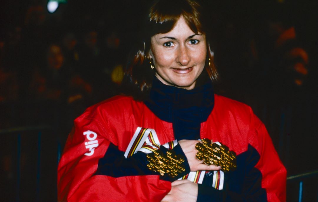 En kvinne holder to gullmedaljer