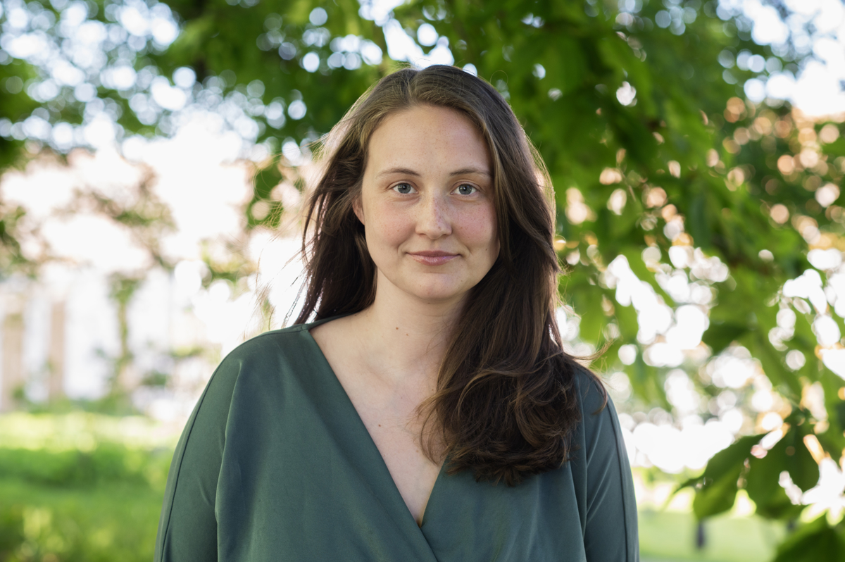 Line Fjørstad smiler mot kamera i grønne omgivelser.