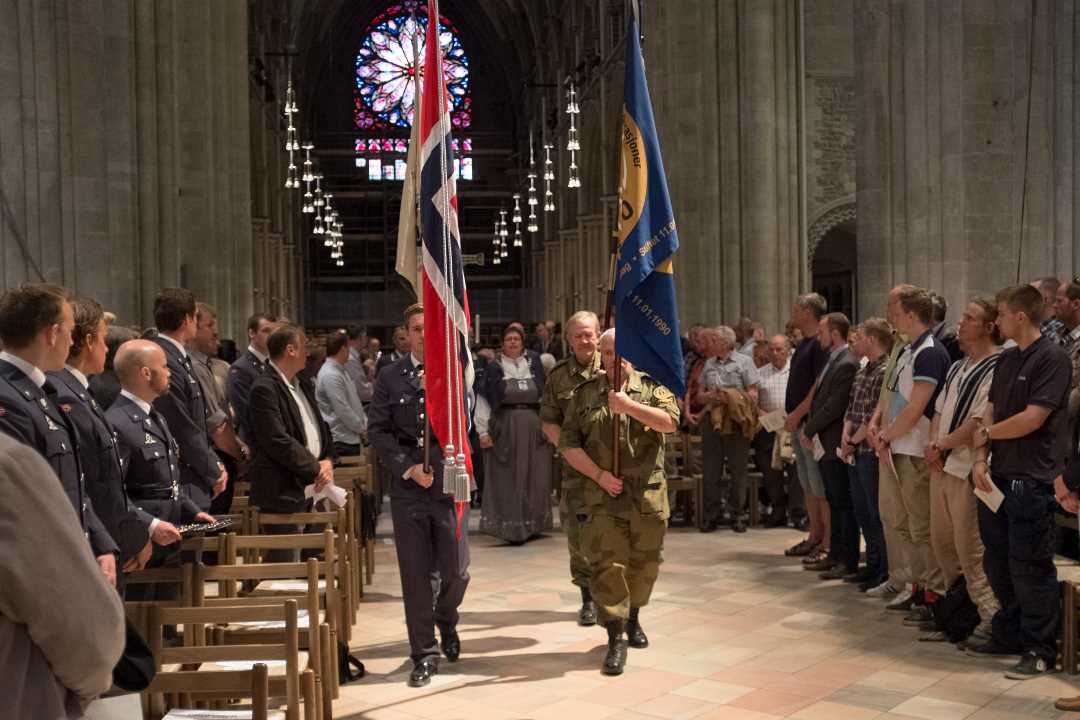 en veteran som bærer et flagg i Nidarosdomen