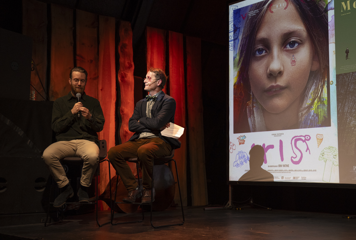 Filmskaper Jon Vatne og byråd Trond Åm sittende på scenen.