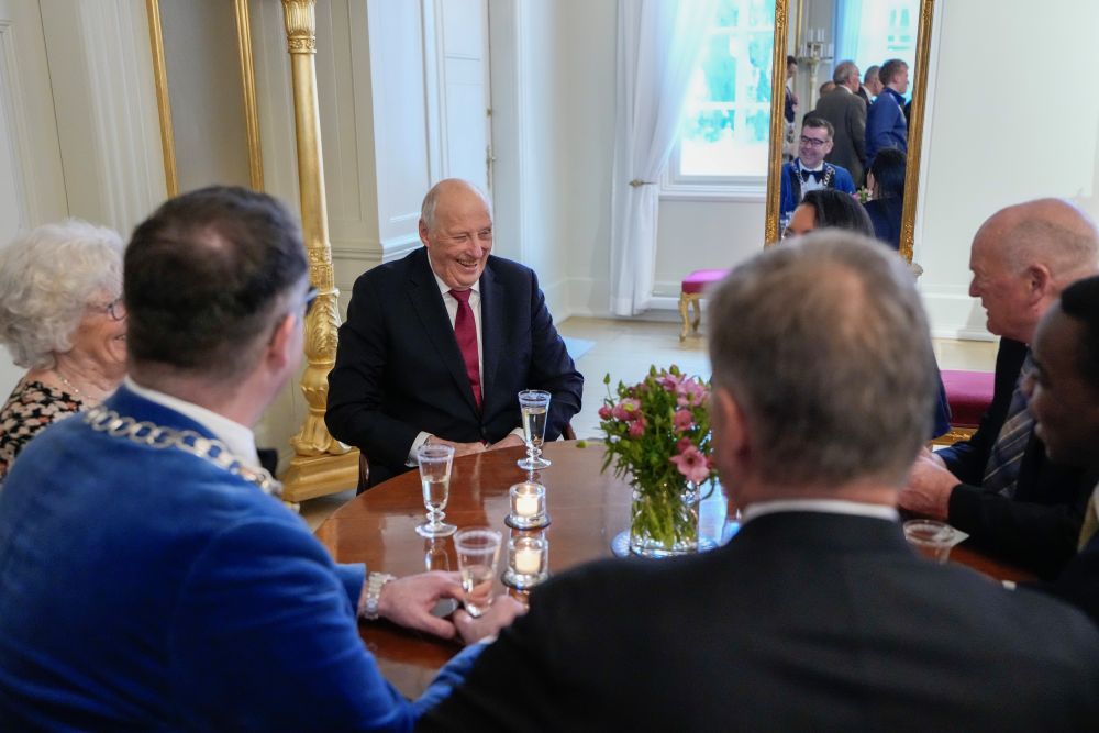 Kong Harald sitter rundt et bord og spiser lunsj med blant annet ordf&oslash;rer. Under ski-vm i 2025.