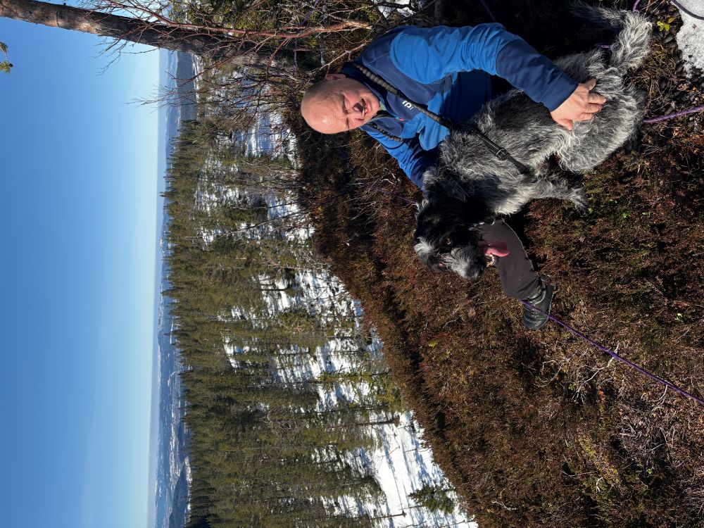 Lag Magnussen med hund sitter et sted i skogen