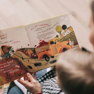 En forelder og et barn leser bildebok sammen