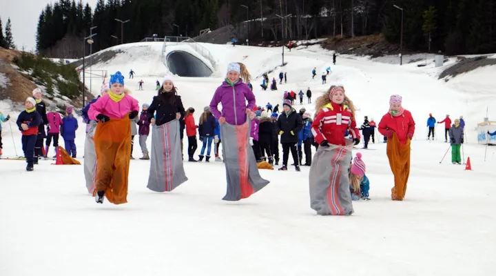 Barn som hopper om kapp i snøen