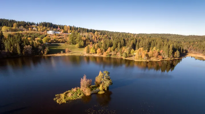 Lianvatnet med øy og gressplen i bakgrunnen