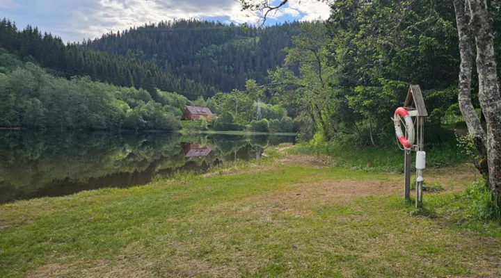 Badeplass ved Nidelva med gressplen og redningsbøyle