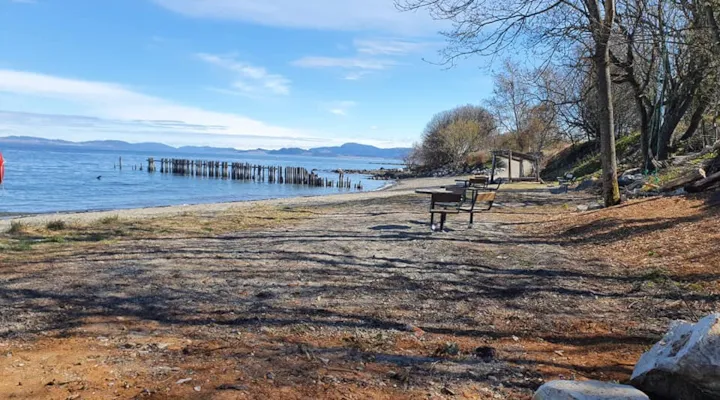 Tømmerstranda ved fjorden med benker og gapahuk