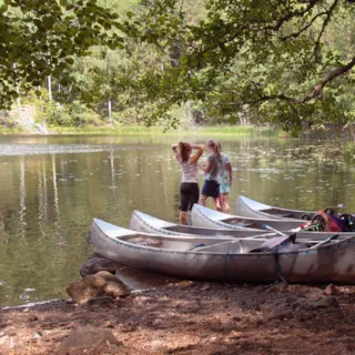 Barn og kanoer ved et vann