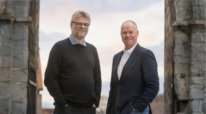Professor Erik Opsahl og kulturdirektør Ola By Rise står under en portal i Erkebispegården