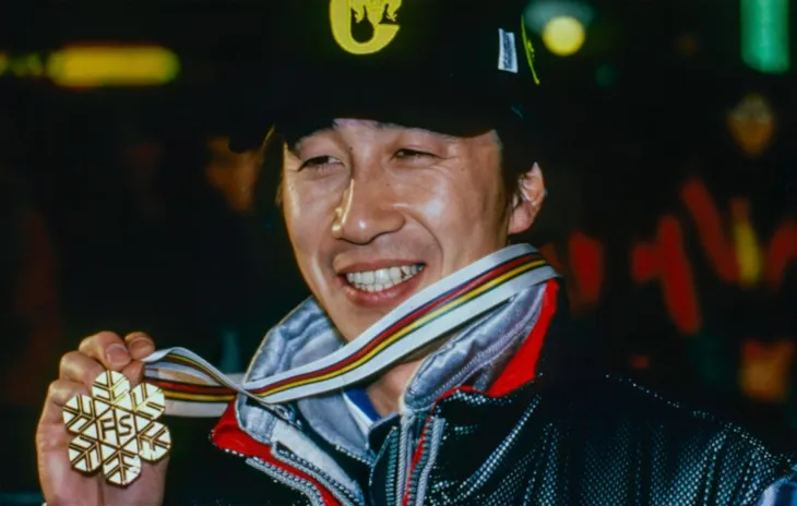 En mann fra Japan viser frem gullmedalje