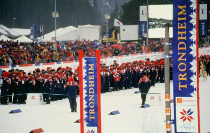 Målseil på skistadion med mange publikummere i bakgrunnen