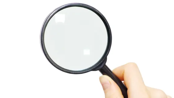 Hånd som holder et forstørrelsesglass