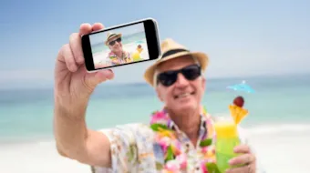Foto av mann på stranda som tar selfie