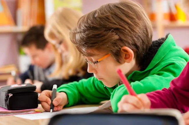 Illustrasjonsfoto av ung gutt på skolebenken