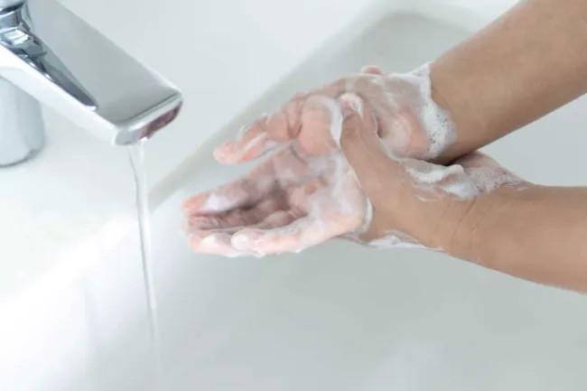 Person som vasker hendene med såpe