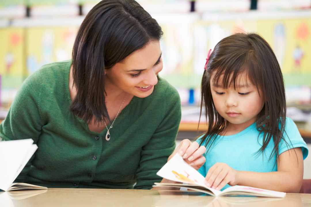 Bilde av lærer som hjelper elev med skolearbeidet
