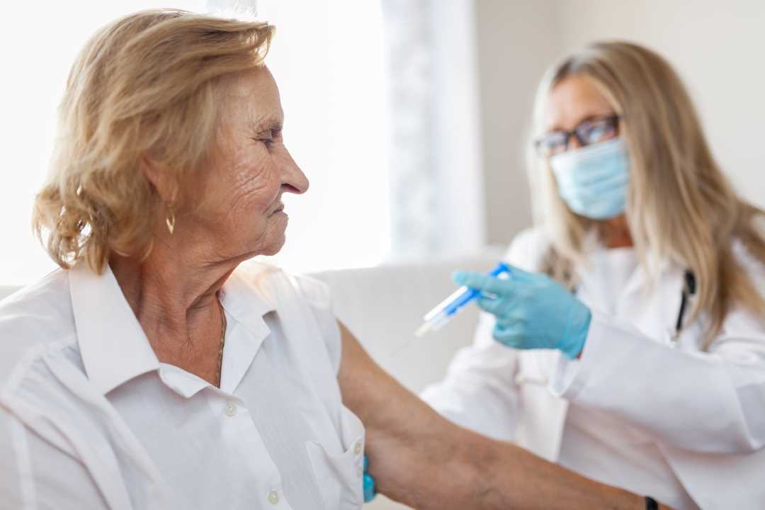 Bilde av eldre kvinne som får vaksine