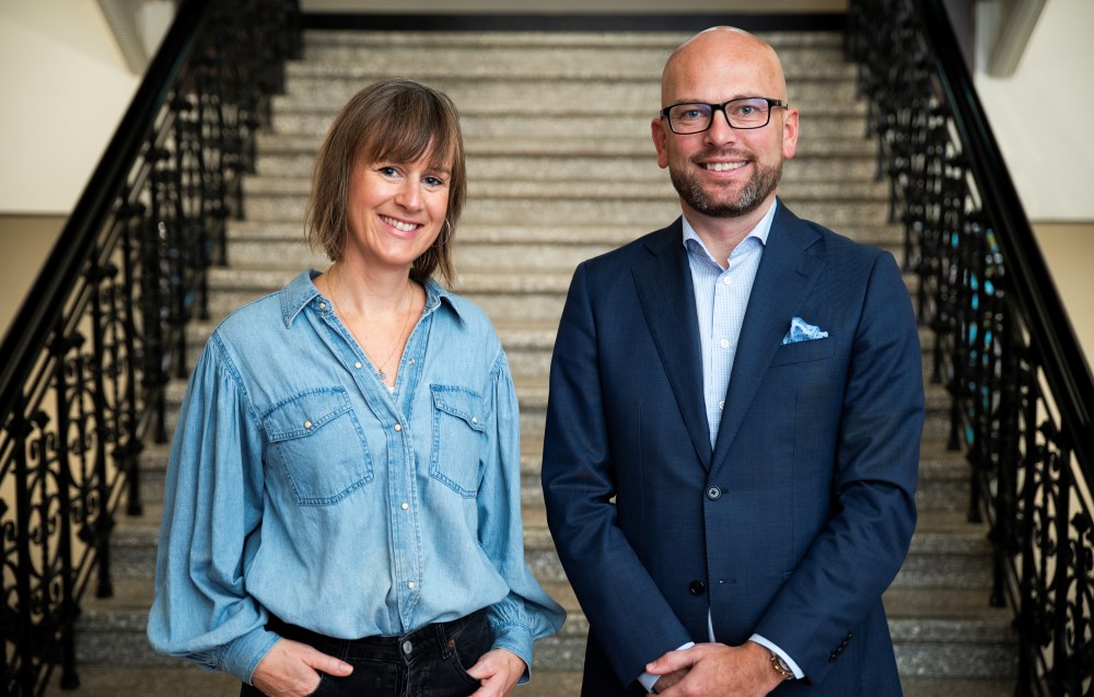 Foto av Michelle Wright og Kristian Dahlberg Hauge stående foran trappen inne i rådhuset i Trondheim