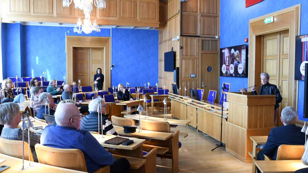 Karen Espelund står og snakker ved talerstolen i bystyresalen på pressekonferansen.