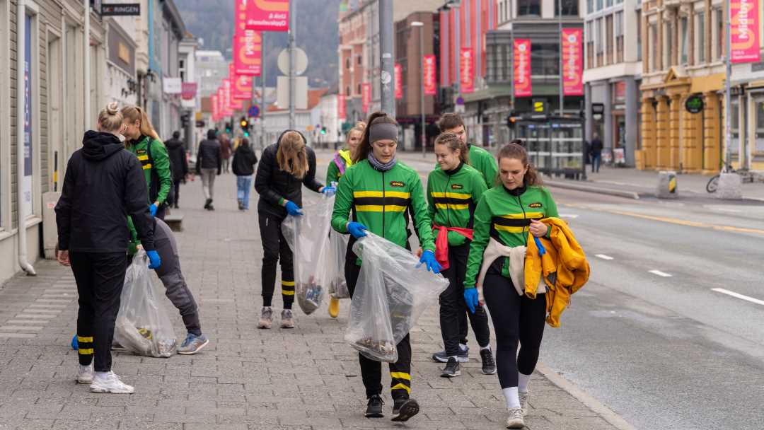 Studenter i NTNUI-treningsdrakter som rydder søppel i Trondheims gater.