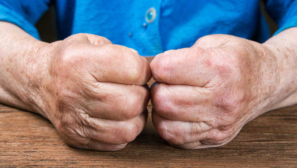 Nærbilde av knyttede hender til en eldre person.
