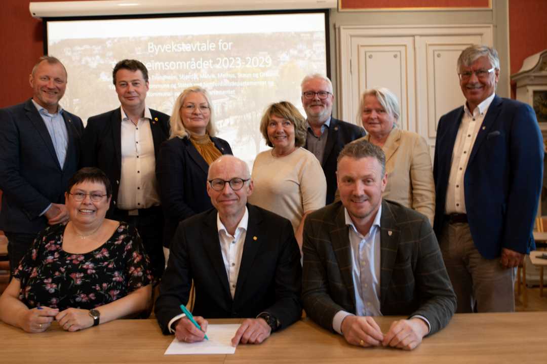 Foto av gruppen som har forhandlet om ny byvekstavtale. Ordfører Rita Ottervik, forhandlingsleder for staten, Per Morten Lund og fylkesvaraordfører Tomas Iver Hallem sitter foran mens de øvrige står bak.