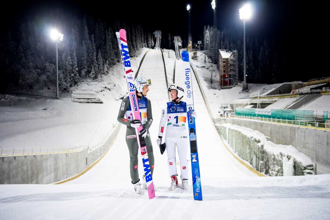 Foto av Johann André Forfang og Eirin Kvandal foran hoppbakkene i Granåsen